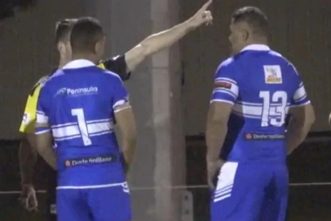 John Hopoate is sent off by the referee who is pointing to the sideline.