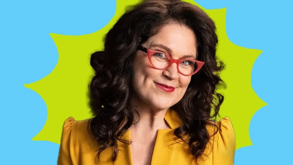 Annabel Crabb looks to the camera with a smile, wearing her signature red glasses cut out against a blue green background