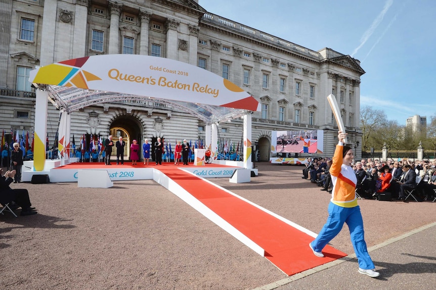 Australian Anna Meares (R), carries Commonwealth Games relay baton at Buckingham Palace.