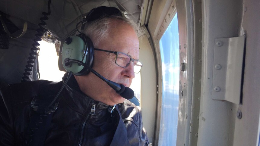Malcolm Turnbull looking out the window in a helicopter, with headset on.