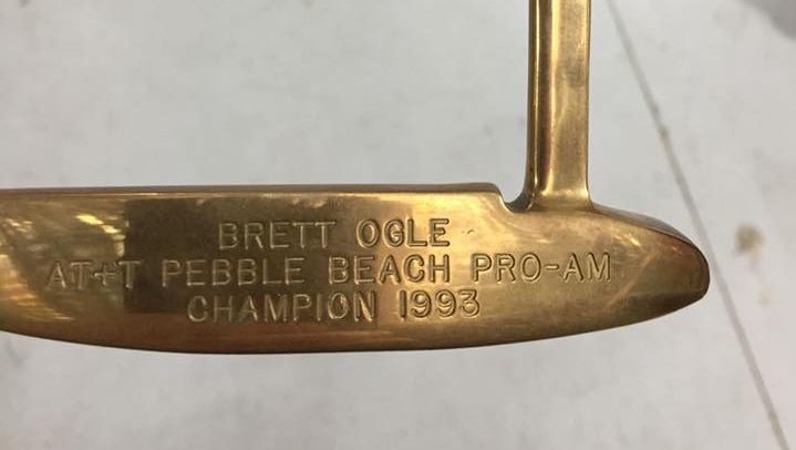 A gold-plated putter engraved with Brett Ogle's name.