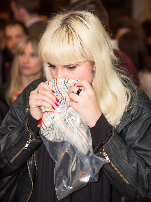 A woman at a pheremone party smells another guest's smelly t-shirt.