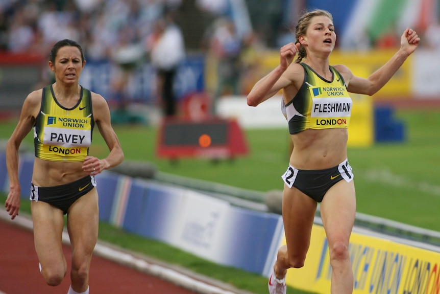 Runner Lauren Fleshman crosses the finish line with her arms raised