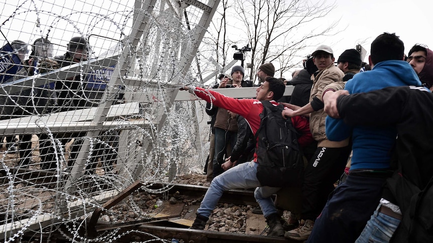 Asylum seekers open the gate at the Greek-Macedonian borders during a protest.
