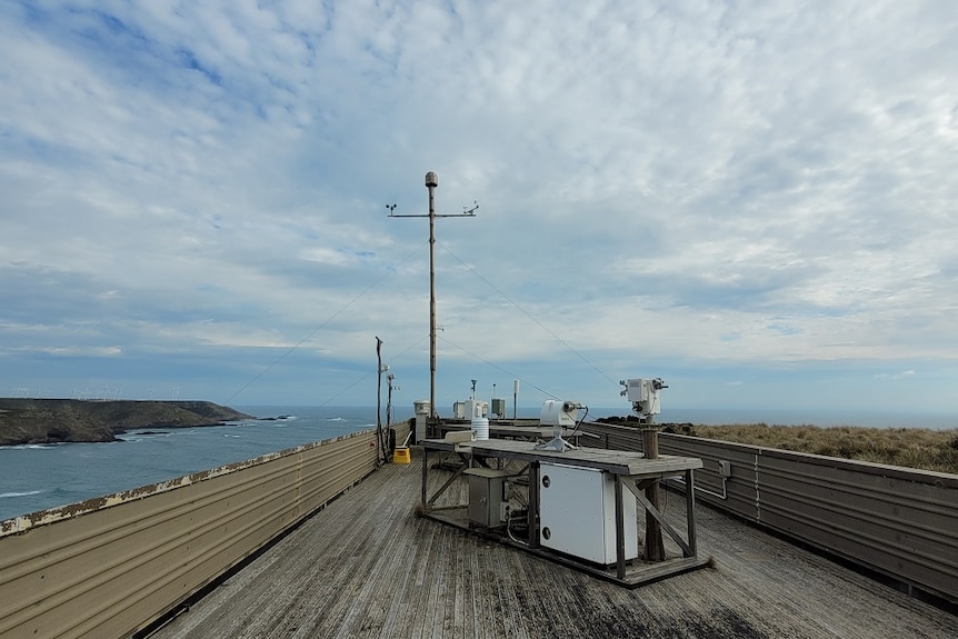 Outside wooden deck with air monitoring equipment under a big sky.