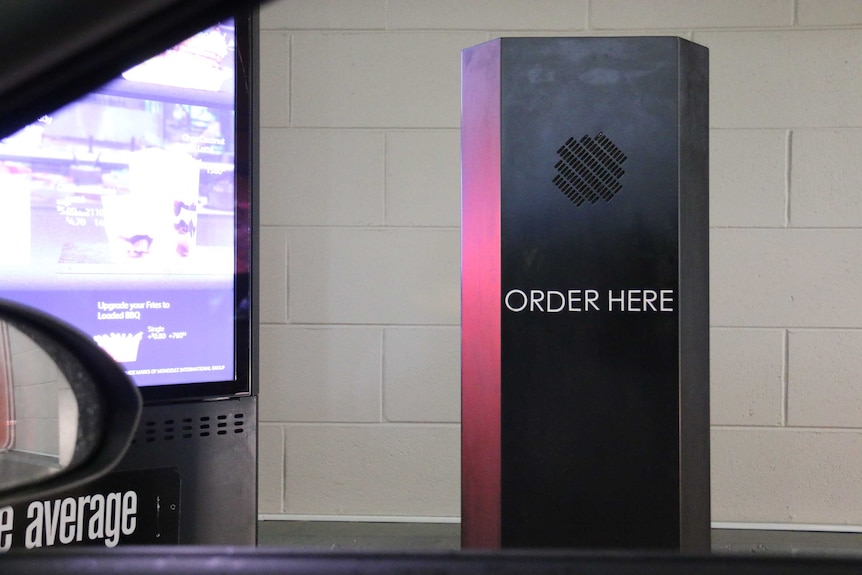 A speaker box where customers order drive-through fast food, which reads 'order here'.