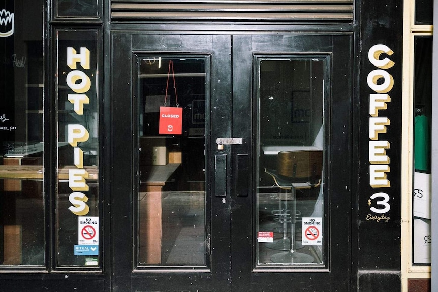 A closed sign in the window of a cafe.