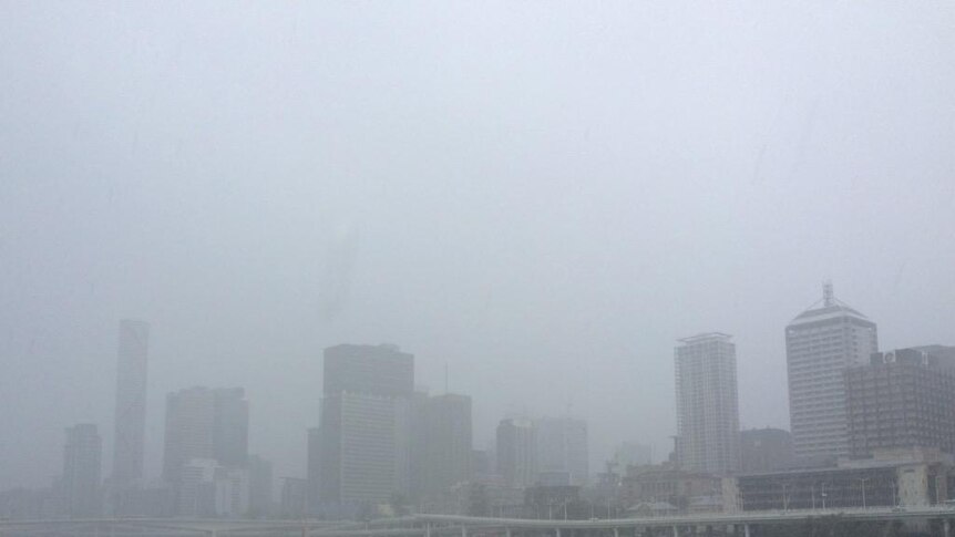 Brisbane CBD barely visible through the rain