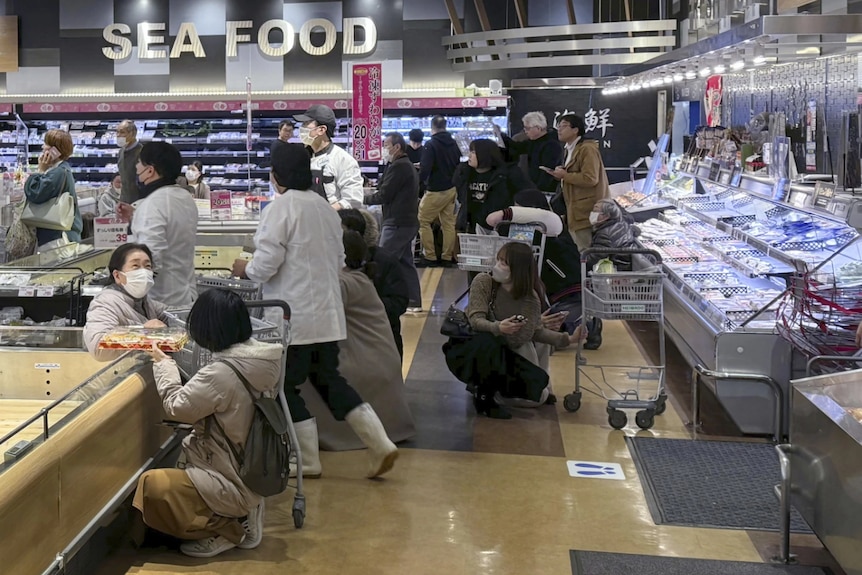 A crowd of people inside a supermarket