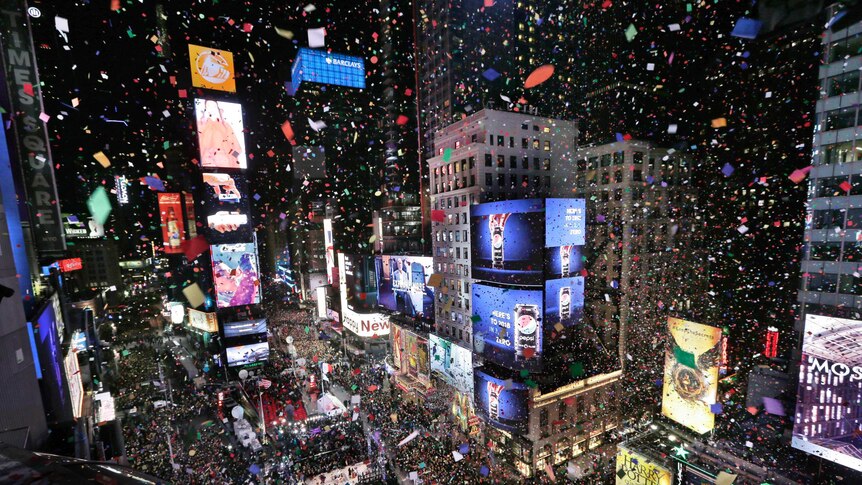Confetti drops over the crowd as the clock strikes midnight during the New Year's celebration in Times Square.