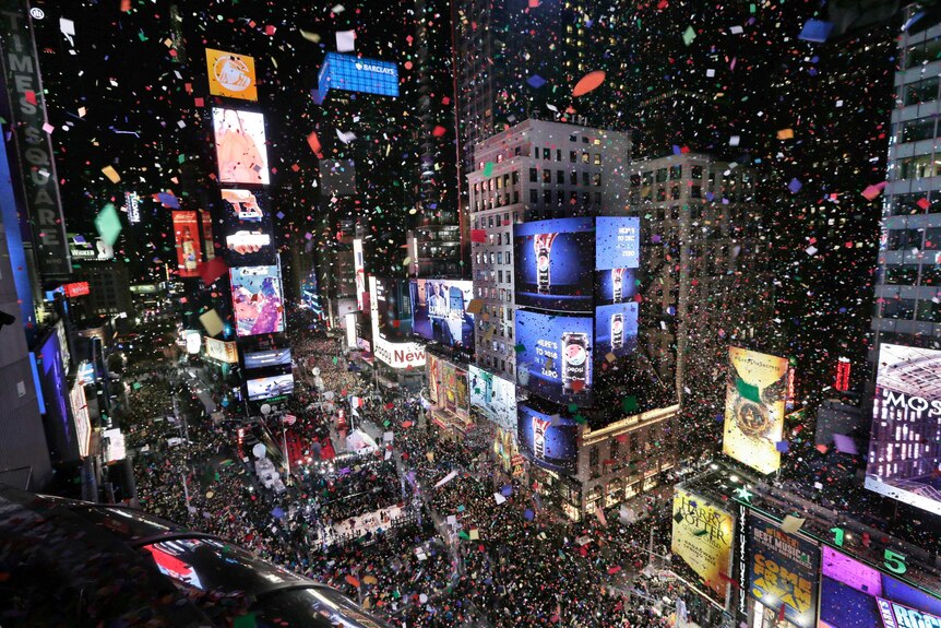 Confetti drops over the crowd as the clock strikes midnight during the New Year's celebration in Times Square.