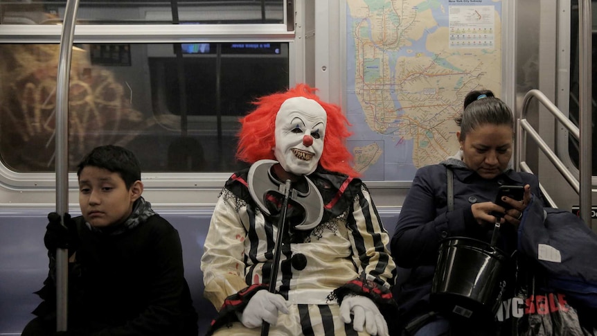 A scary clown takes a seat on the subway