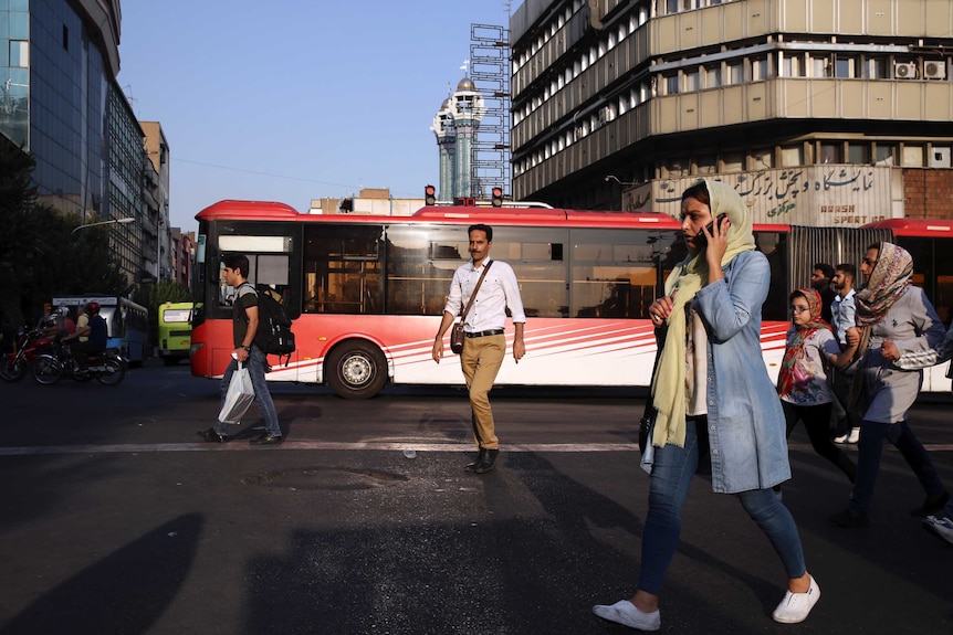 People cross Jomhouri-e-Eslami (Islamic Republic) Street in downtown Tehran
