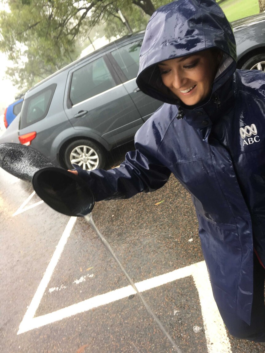 Horn in ABC raincoat tipping water out of gumboot.