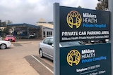 a sign with the Mildura Health Private Hospital logo in front of a car park and a building
