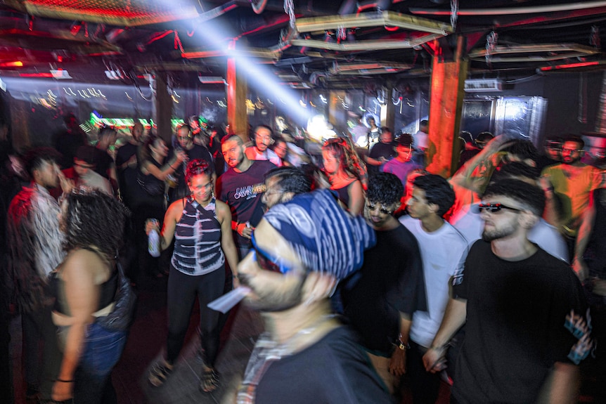 people dance on a crowded dance floor inside a restaurant turned dance hall in Cairo