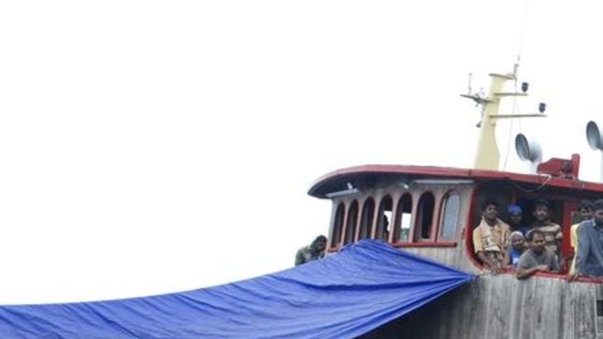 An Indonesian journalist takes a photograph of a Sri Lankan ship detained by the Indonesian Navy