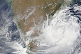 A picture showing large swirling white clouds over earth.