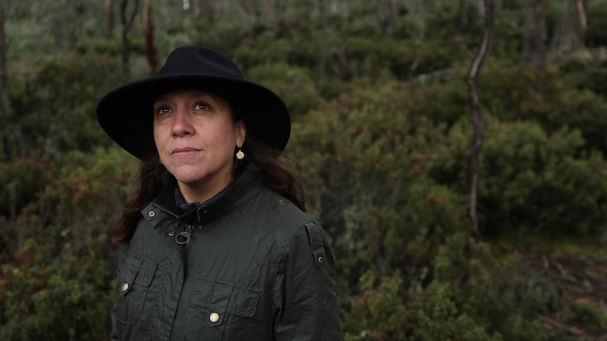 Rachel Perkins stands in woodland with Akubra hat on