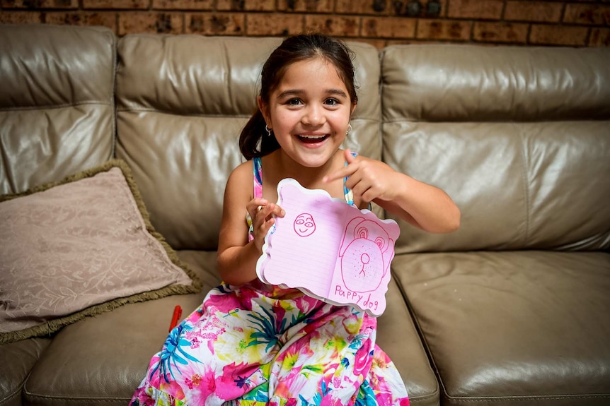 Karla De Lautour with a picture she drew of a dog.