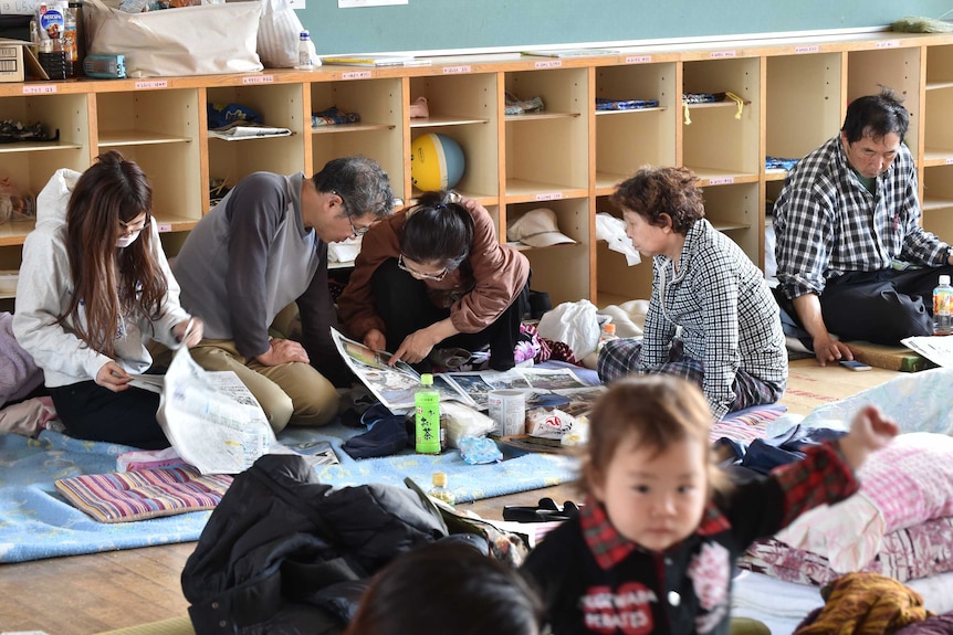 Japanese evacuees rest at an elementary school