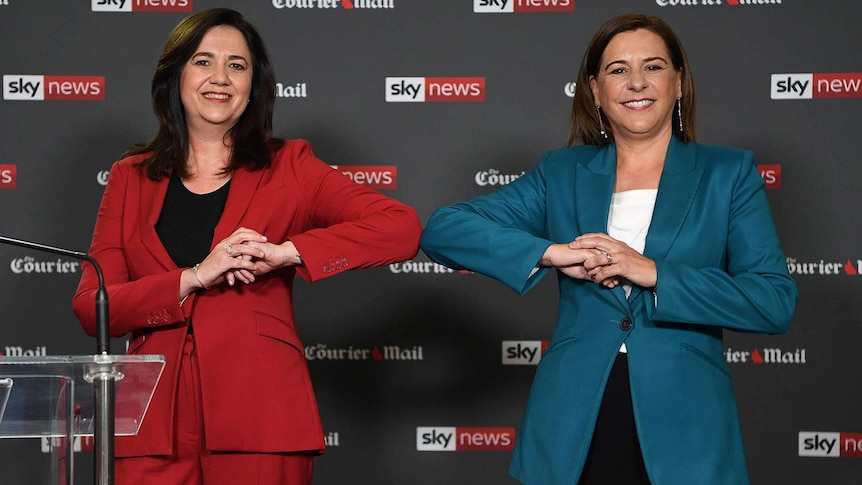 Annastacia Palaszczuk (left) and Deb Frecklington bump elbows ahead of a political debate