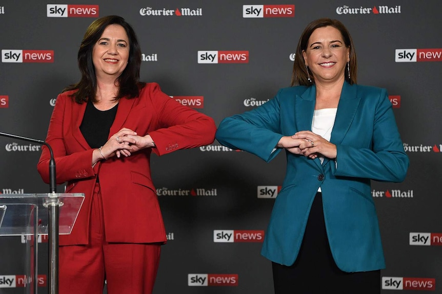 Annastacia Palaszczuk (left) and Deb Frecklington bump elbows ahead of a political debate