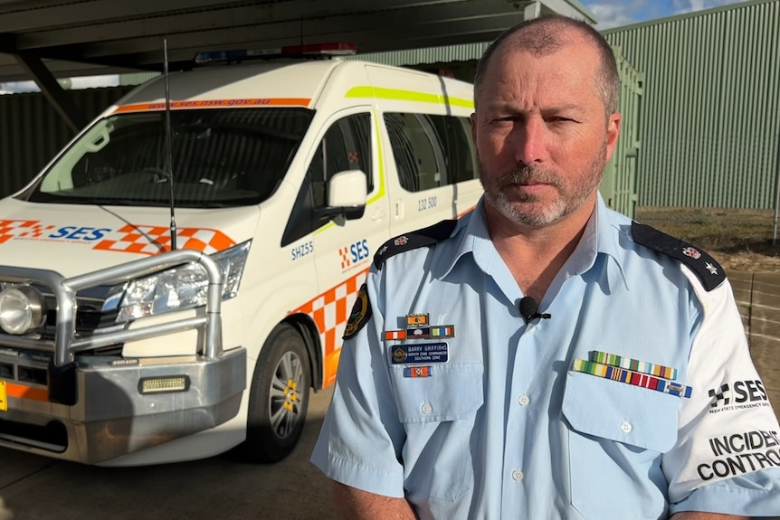 SES officer Barry Griffiths in front of an SES van/ 