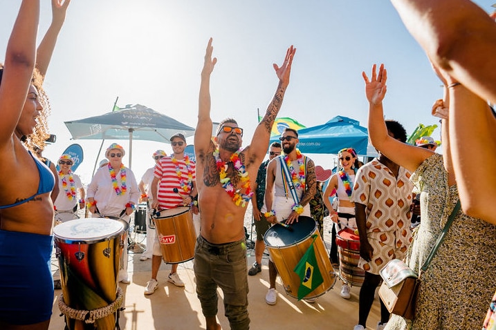 man dances in the sun with crowd 