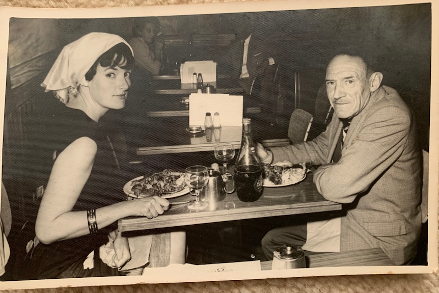 a black and white photograph of a woman and her father at a restaurant