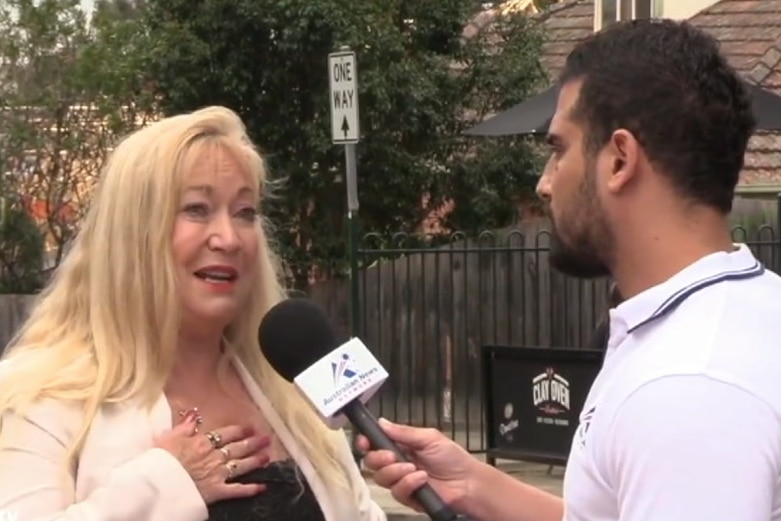 A still from a video showing Meralyn Klein speaking into a microphone held by Avi Yemini.