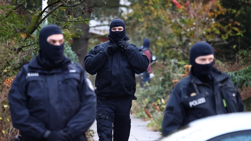 Police in tactical gear and balaclavas. 
