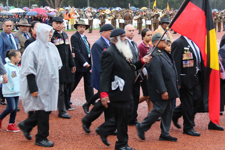 Veterans march in the rain.