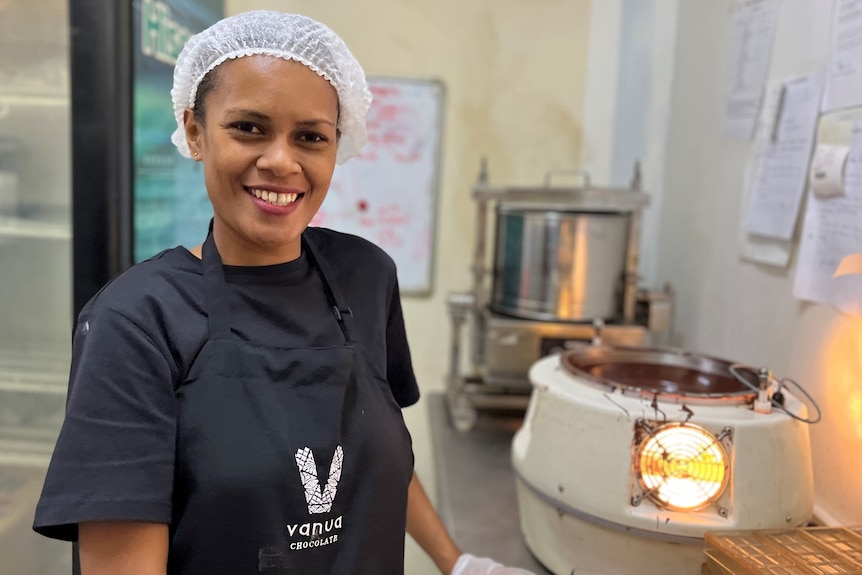Fijian woman smiling at camera whilst in a chocolate production facility. 