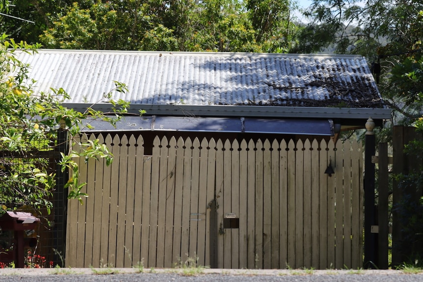 A tall fence in front of a house