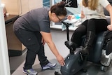 A woman demonstrates how a chemo patient would exercise during chemo treatment as part of a research trial.