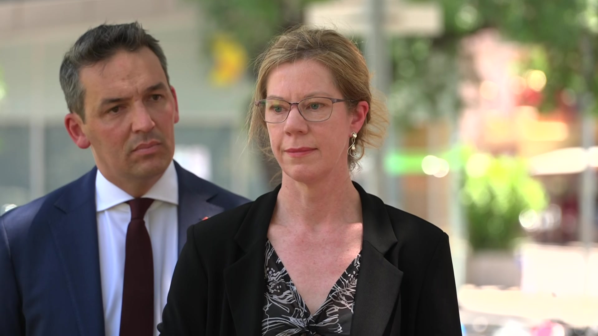 Kerrie Mahon está afuera de Blair Boyer, vestida de negocios y luciendo seria.