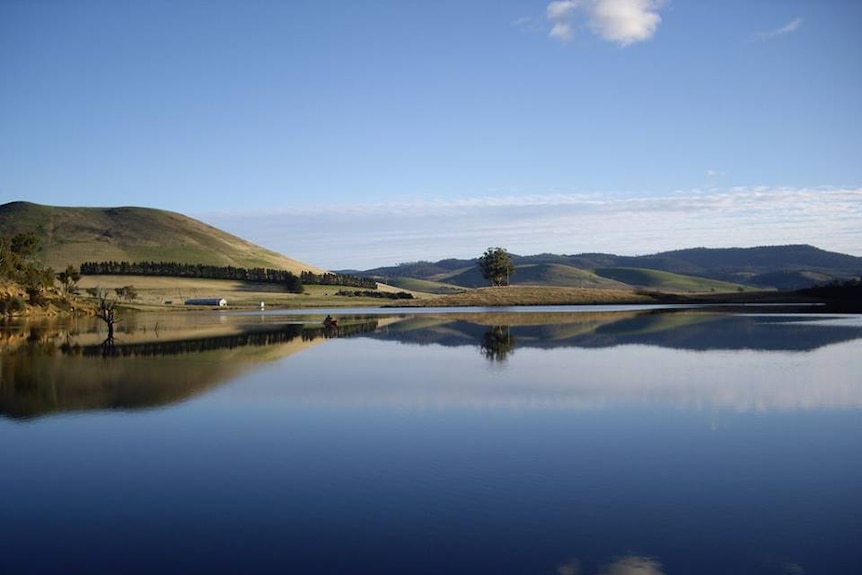 Craigbourne dam still as glass surrounded by rolling hills