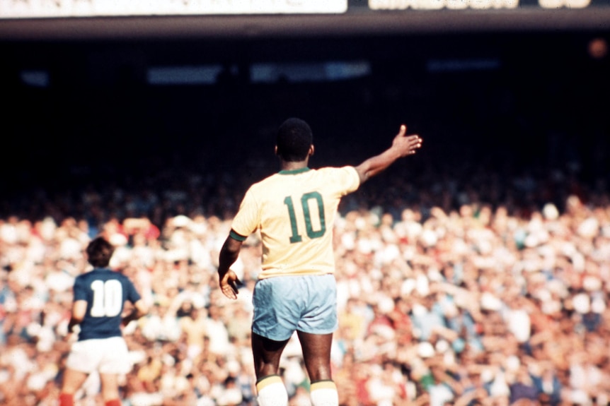 Pele as seen from behind points wearing the Brazil yellow number 10 shirt