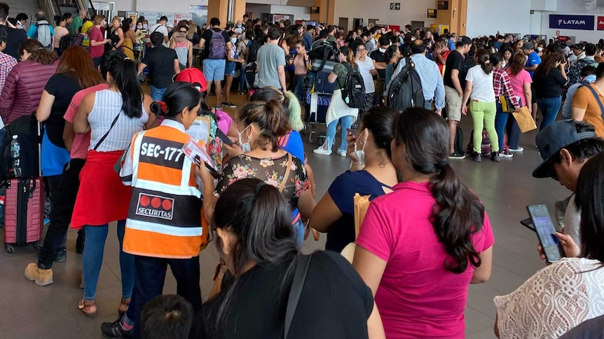 Hundreds of people packed together at an airport in Peru.