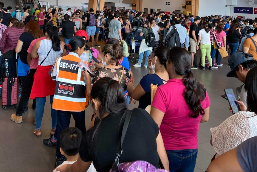 Hundreds of people packed together at an airport in Peru.