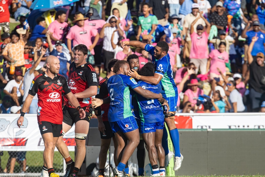 A group of Fijian rugby players celebrate a try during a match