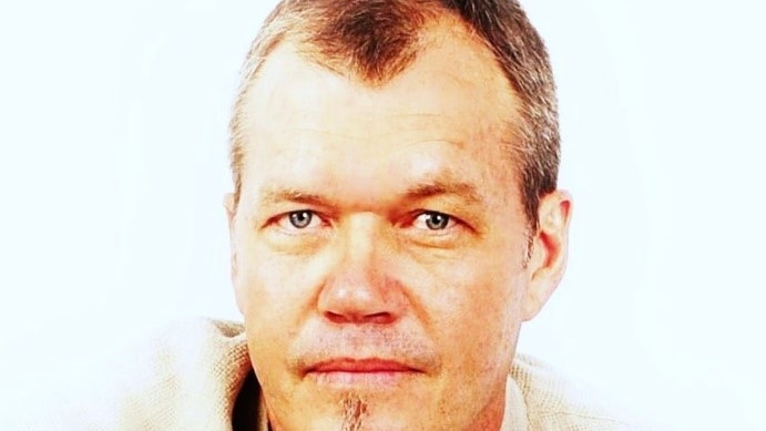 A headshot of a man in his 40s