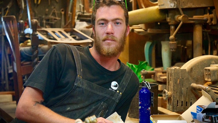 A man leans in his furniture workshop in Port Kembla.