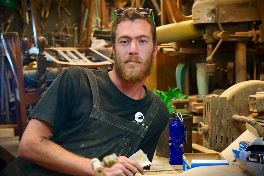 A man leans in his furniture workshop in Port Kembla.