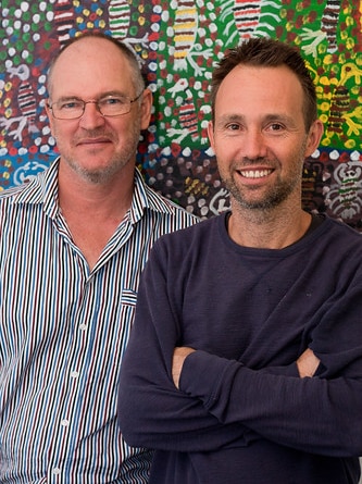 Mark Grose (right) and Michael Hohnen (left) standing in front of an Indigenous painting.