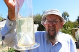 Peter Jones looks at his rainfall gauge at his home in Orford