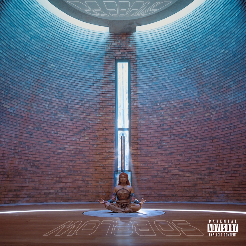 The art for Sampa The Great's album As Above So Below sitting crosslegged on the floor behind a circular brickwall & light beam
