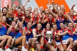 Melbourne celebrates on stage with the AFLw premiership cup after winning the grand final.