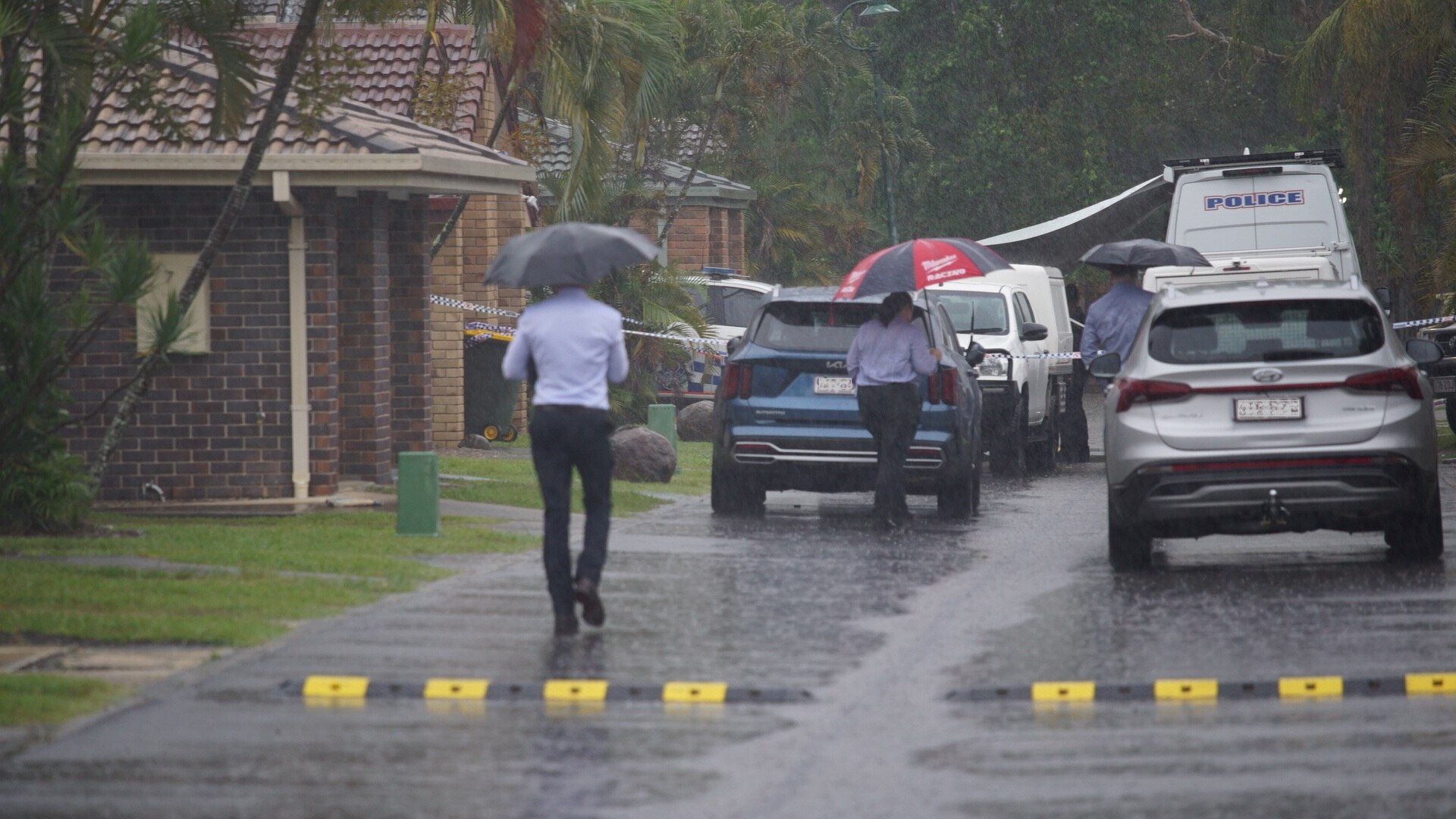 Police cars parked in a driveway near a crime scene